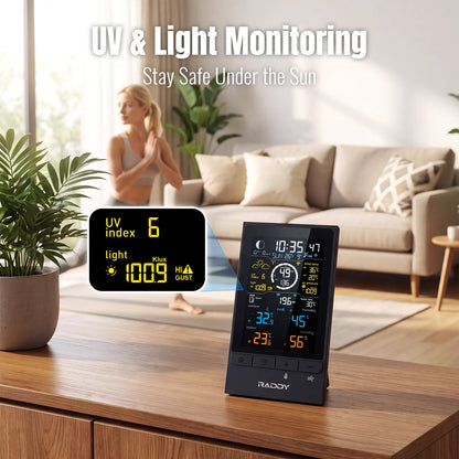 A digital UV and light monitor Raddy UV7 stands on a wooden table in a living room setting, with a woman exercising in the background. The monitor displays real-time weather and UV index information, with an inset showing the screen details.